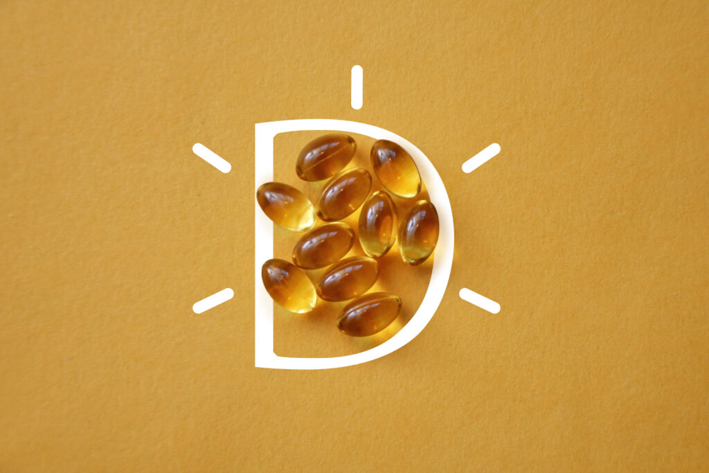 Vitamine D in capsules op een gele achtergrond